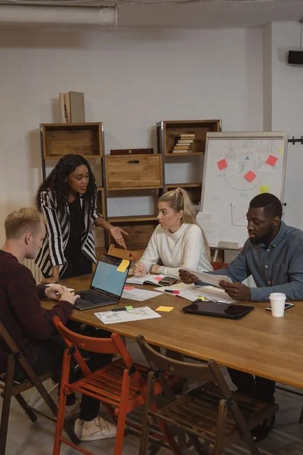 Une équipe diversifiée travaillant ensemble sur des stratégies de marketing digital à un bureau, avec des ordinateurs portables et des tablettes.